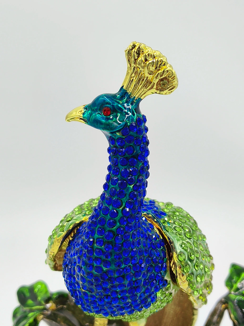 Close-up of brass enamel peacock figurine with blue and green artificial stones