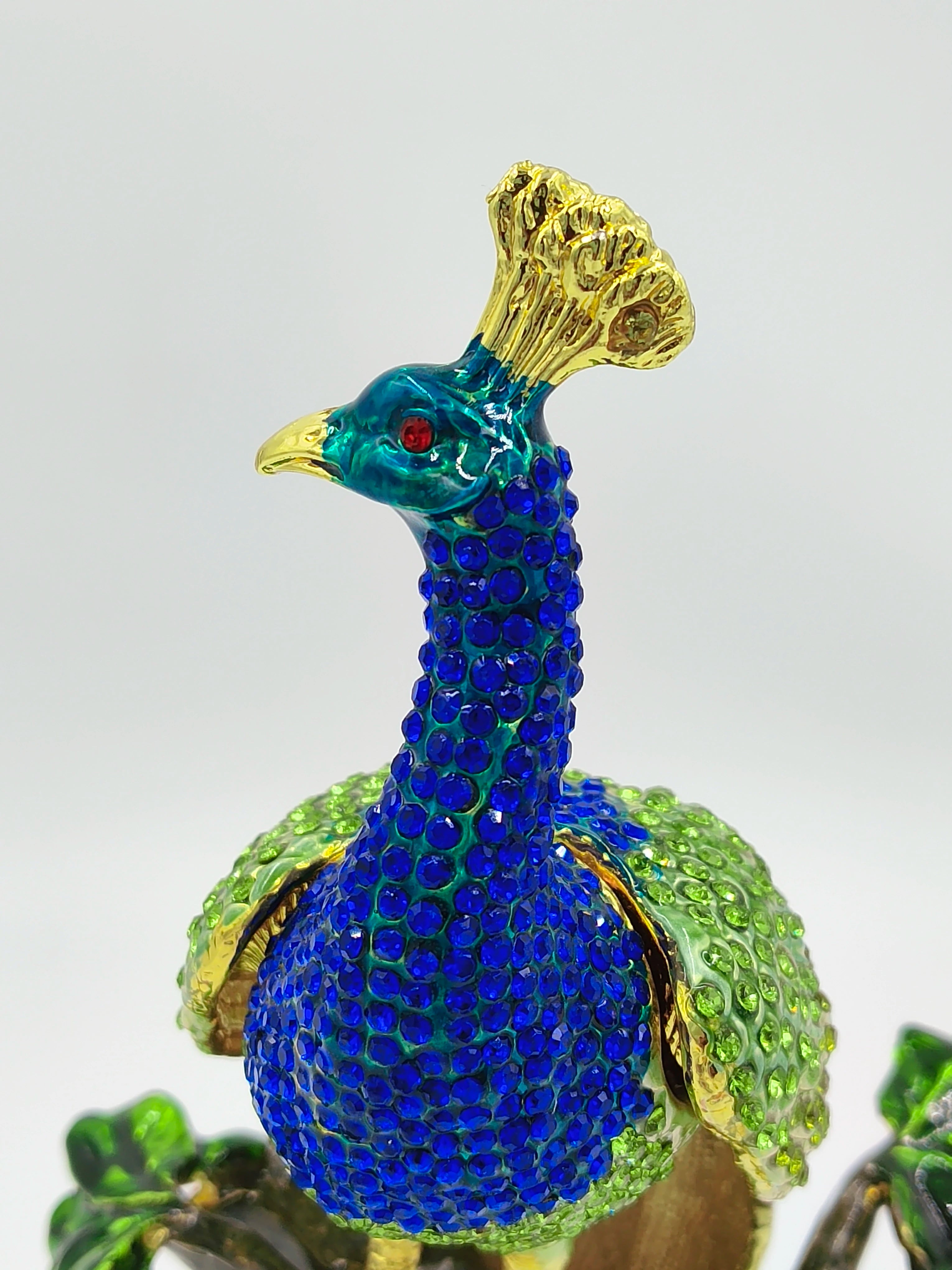 Close-up of brass enamel peacock figurine with blue and green artificial stones