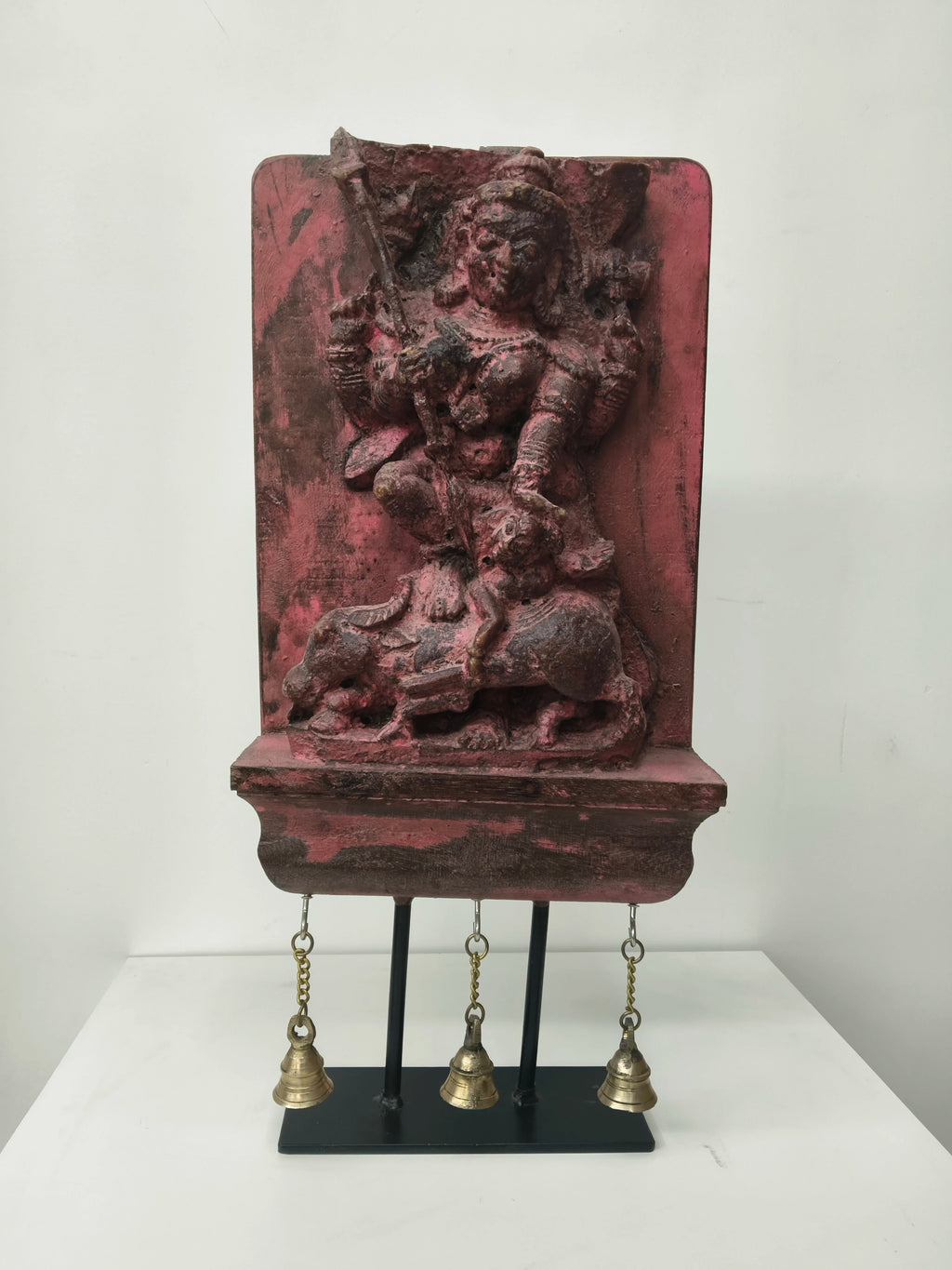 Large wooden Mahishasura Mardini sculpture with three hanging brass bells on black stand