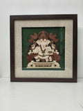 Medium wooden wall art of Lord Ganapathi in a dark brown frame with textured beige mat