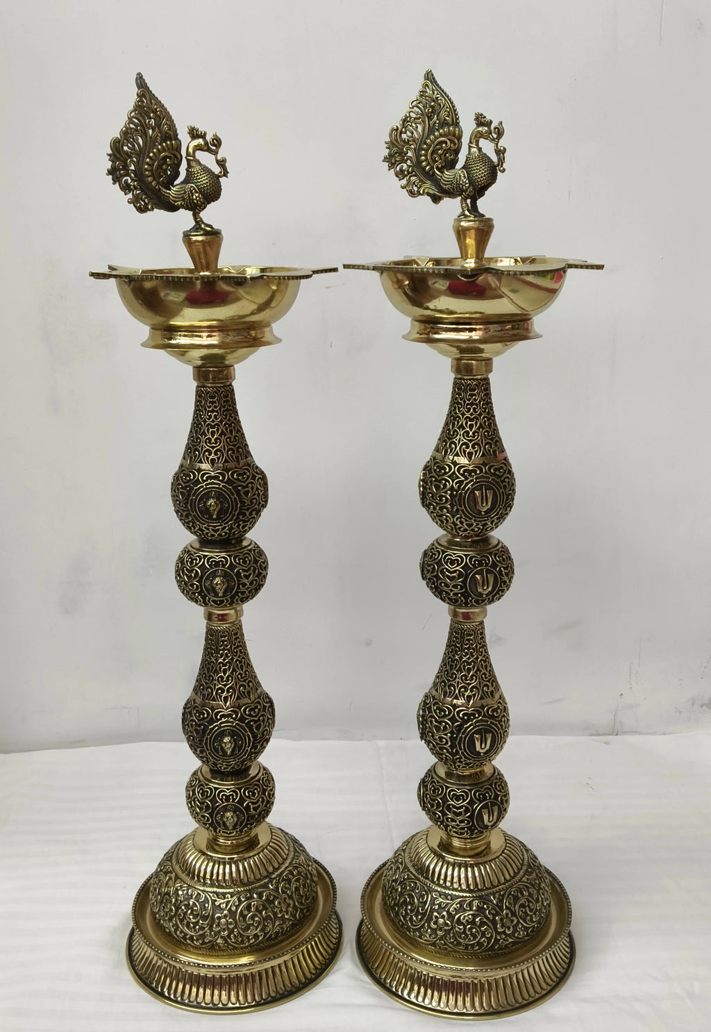 Pair of large brass lamps with detailed peacock figurines on top
