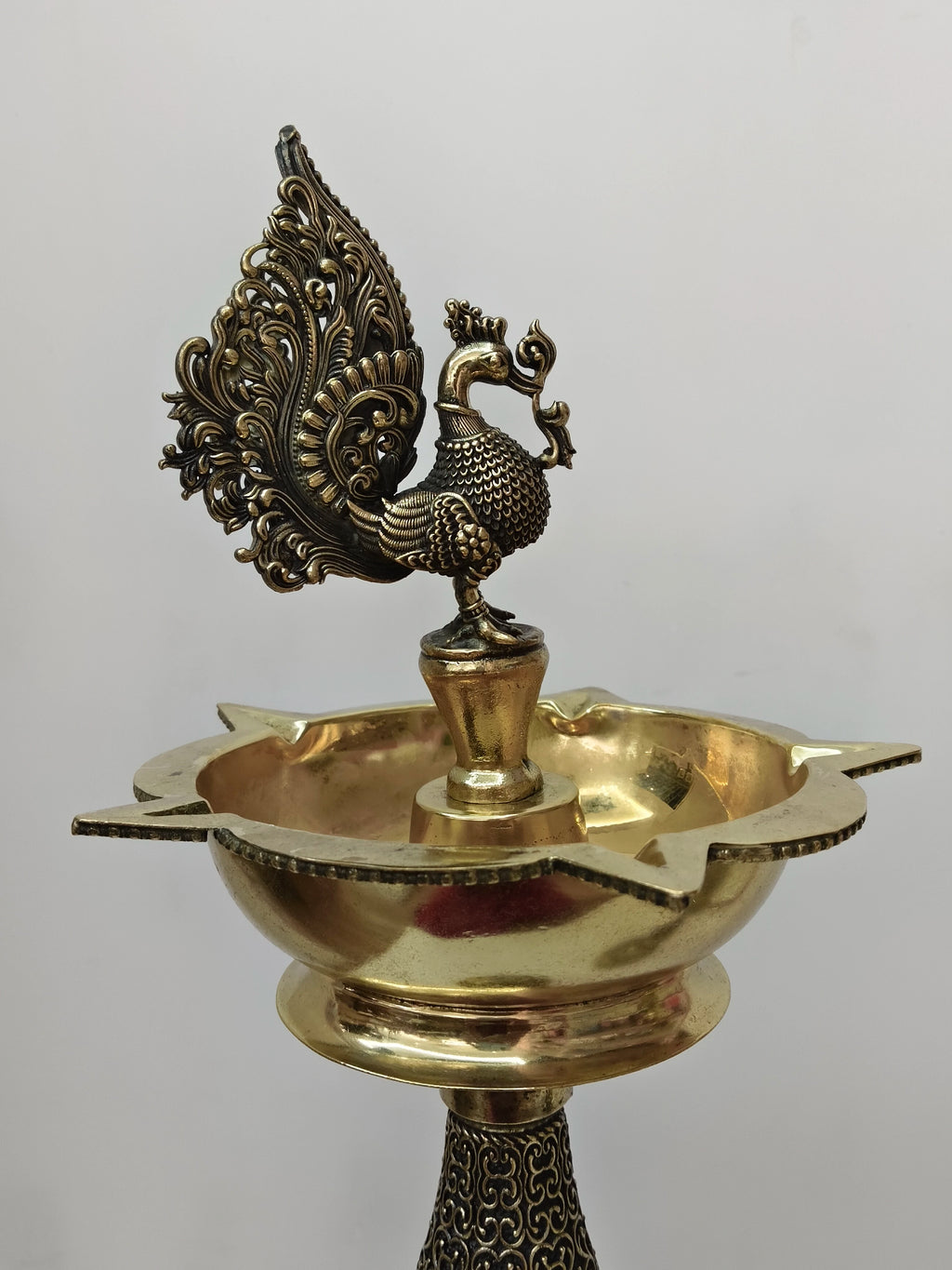 Brass royal peacock lamp with intricate tail design and wide bowl