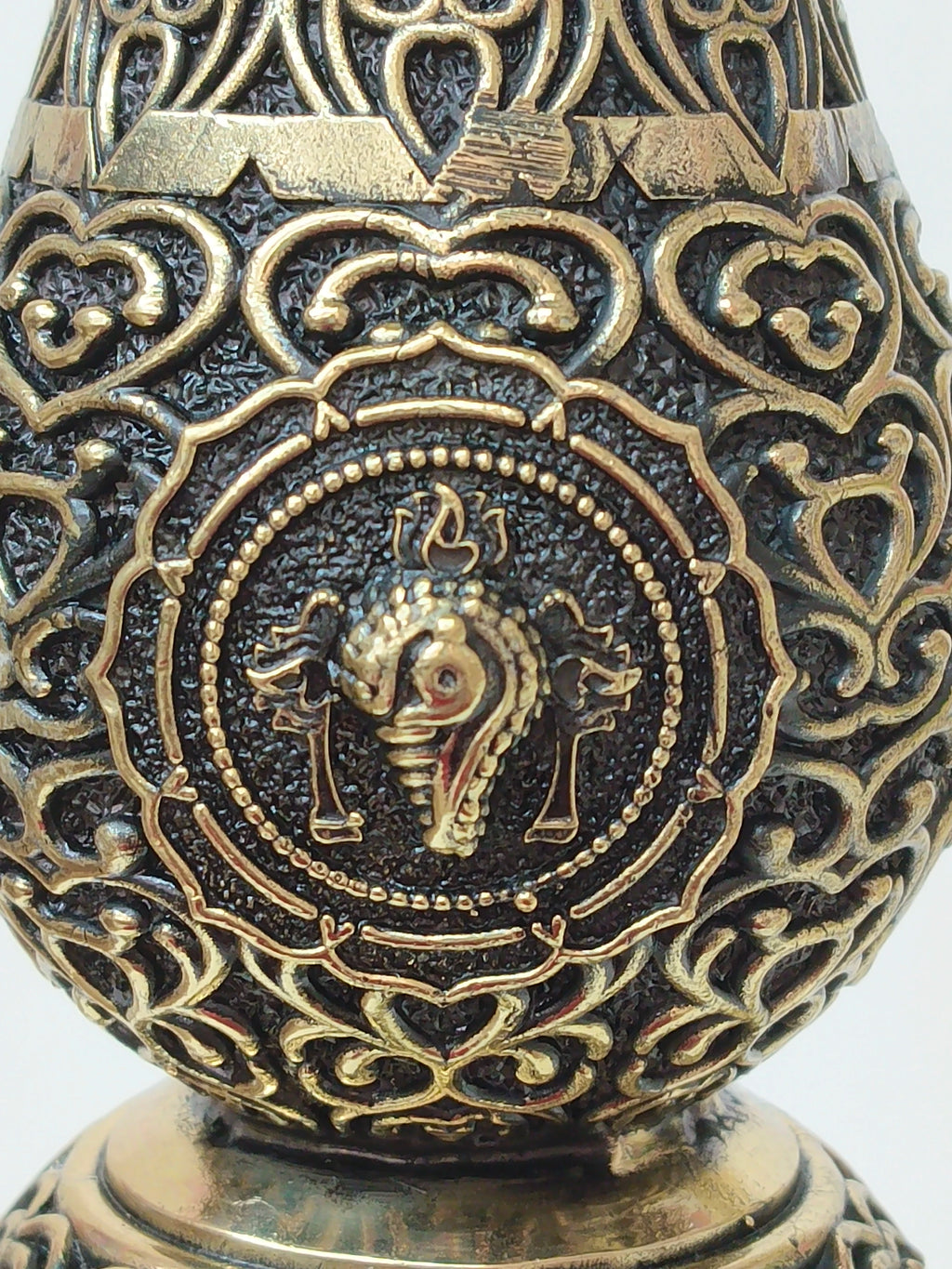 Close-up detail of a brass royal peacock lamp with intricate engraved patterns