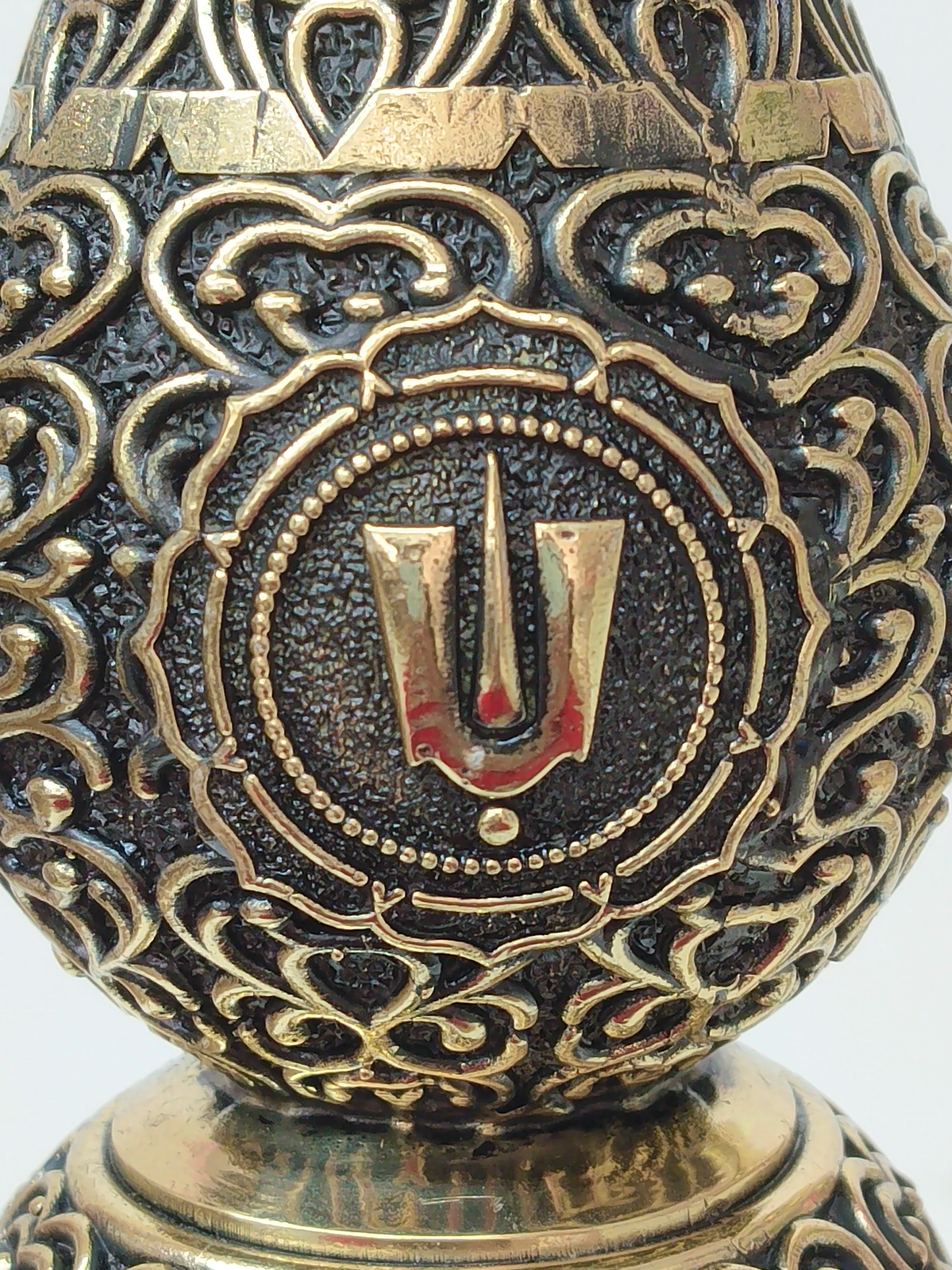 Close-up of detailed brass carving on Royal Peacock Lamp with spiritual symbol