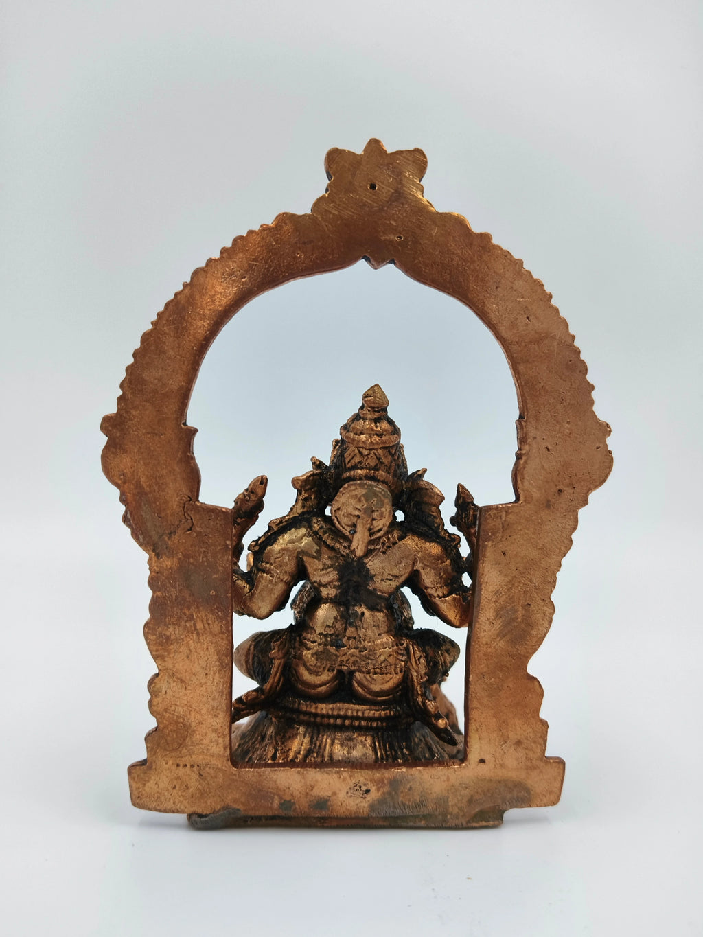 Back view of medium-sized brass Ganesh statue with decorative arch