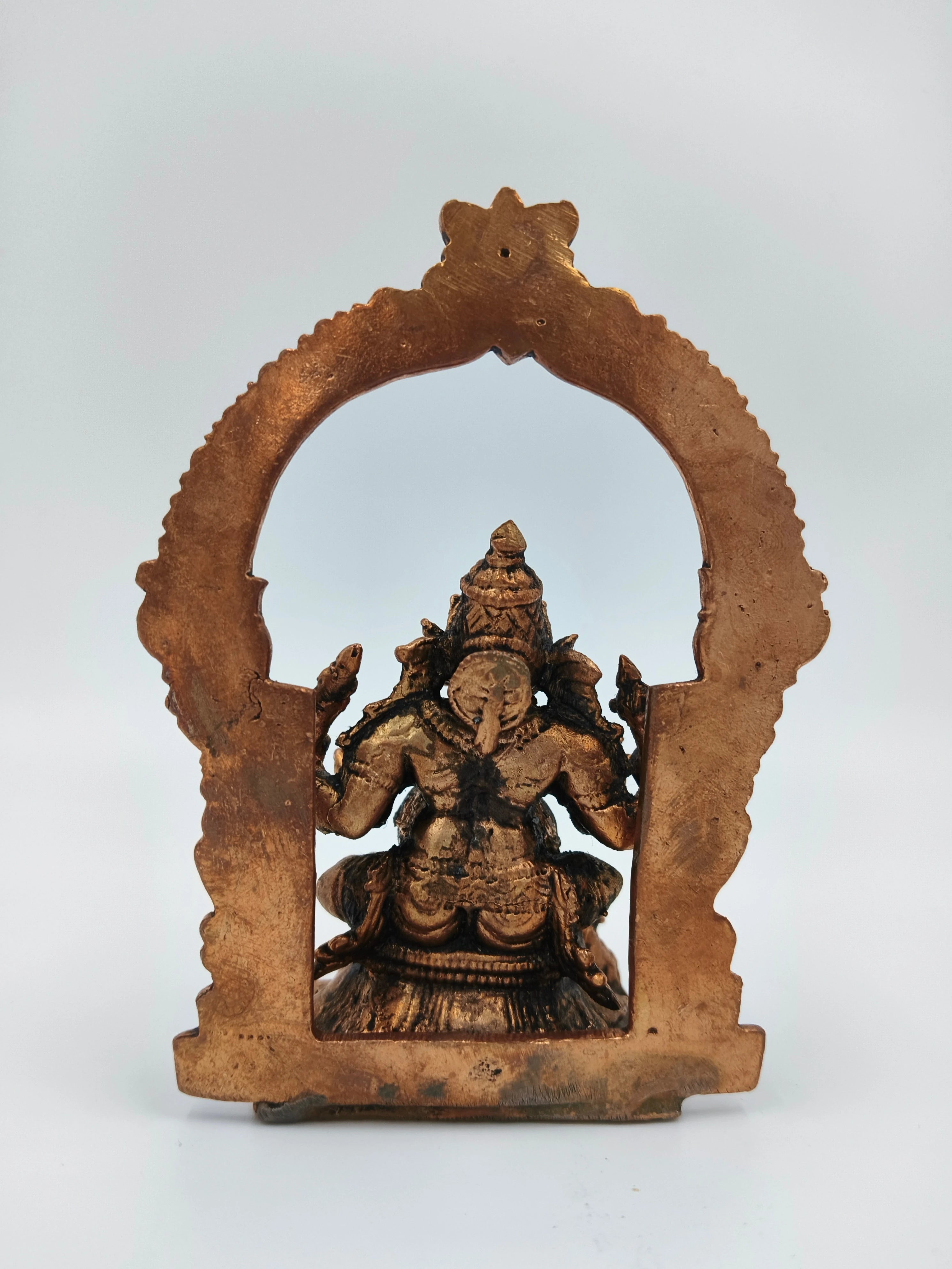 Back view of medium-sized brass Ganesh statue with decorative arch