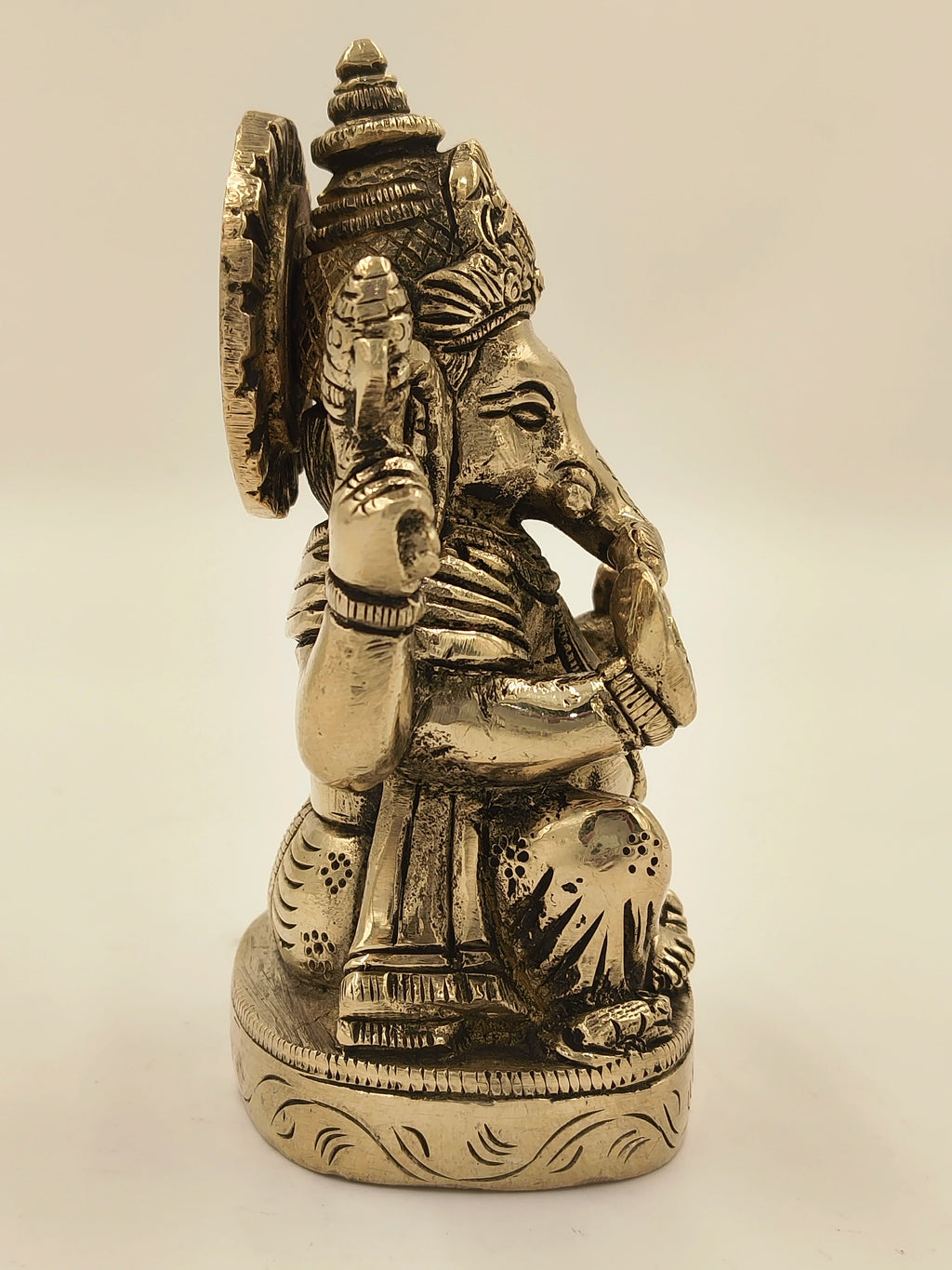Side view of brass Ananda Ganapathi statue with detailed engravings