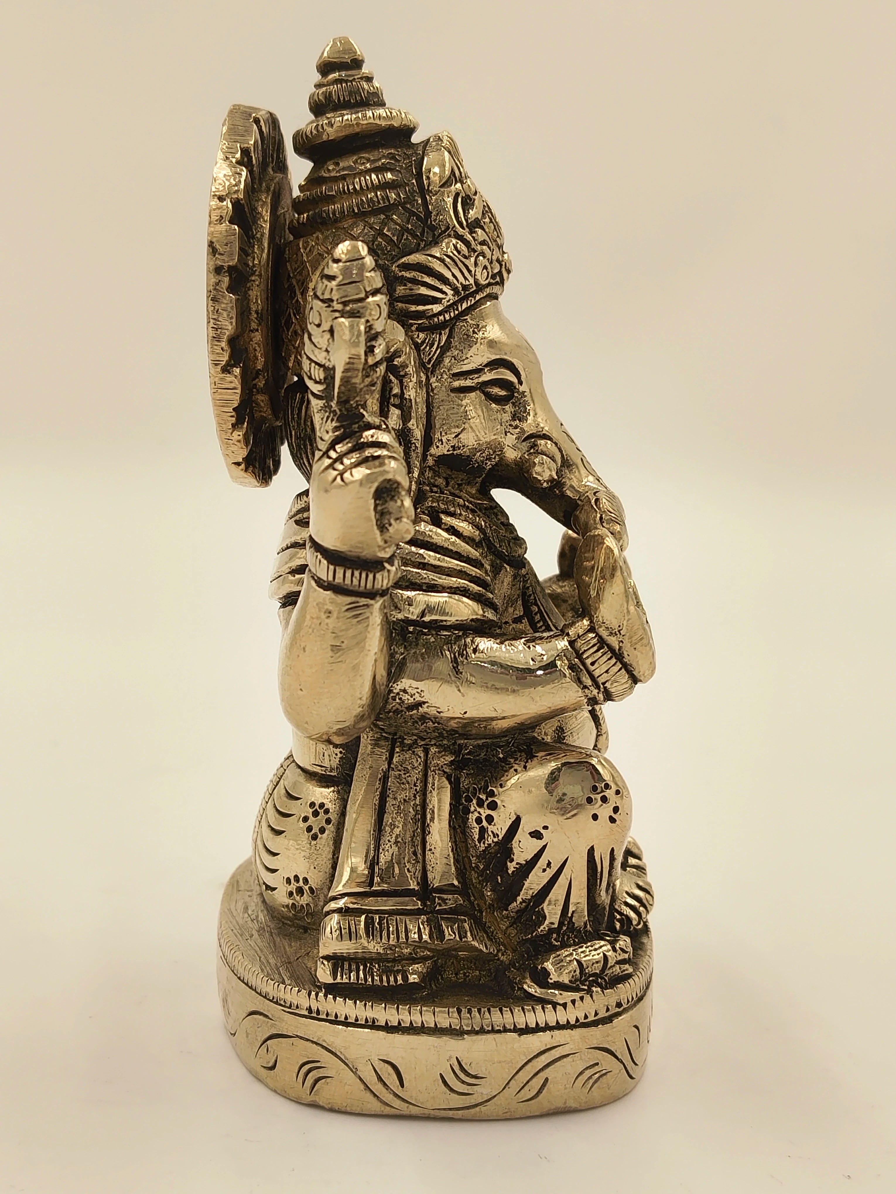 Side view of brass Ananda Ganapathi statue with detailed engravings