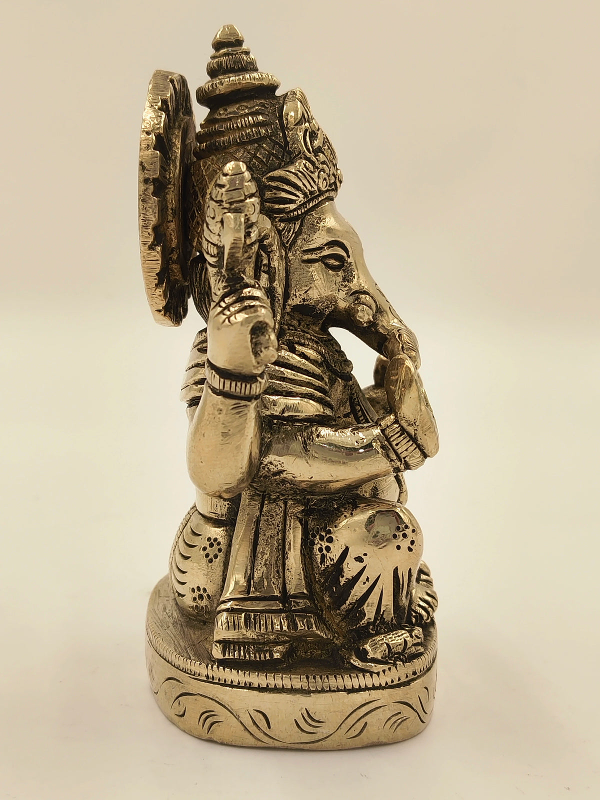 Side view of brass Ananda Ganapathi statue with detailed engravings