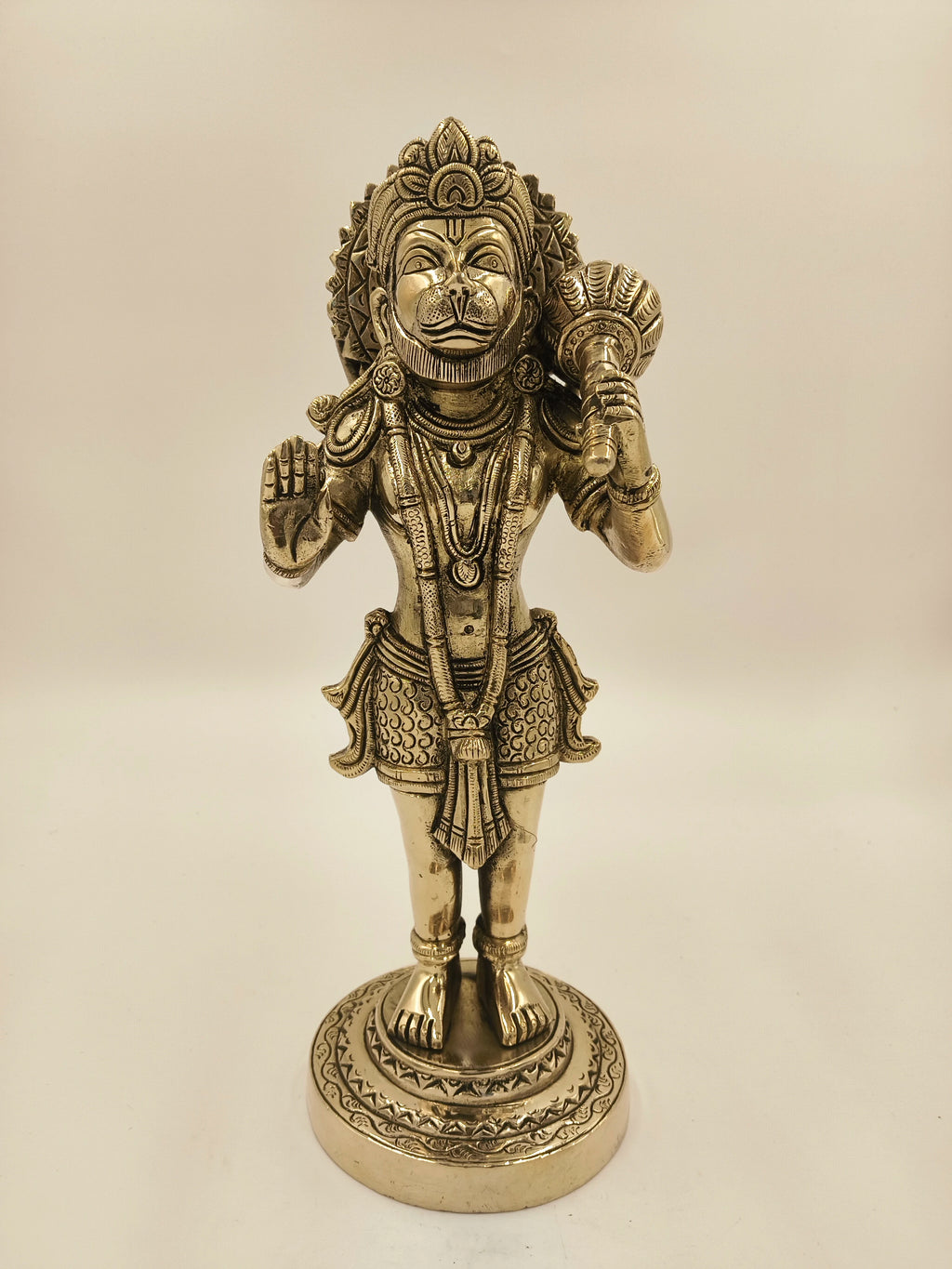 Large brass figurine of Hanuman holding a mace, standing on a decorative base
