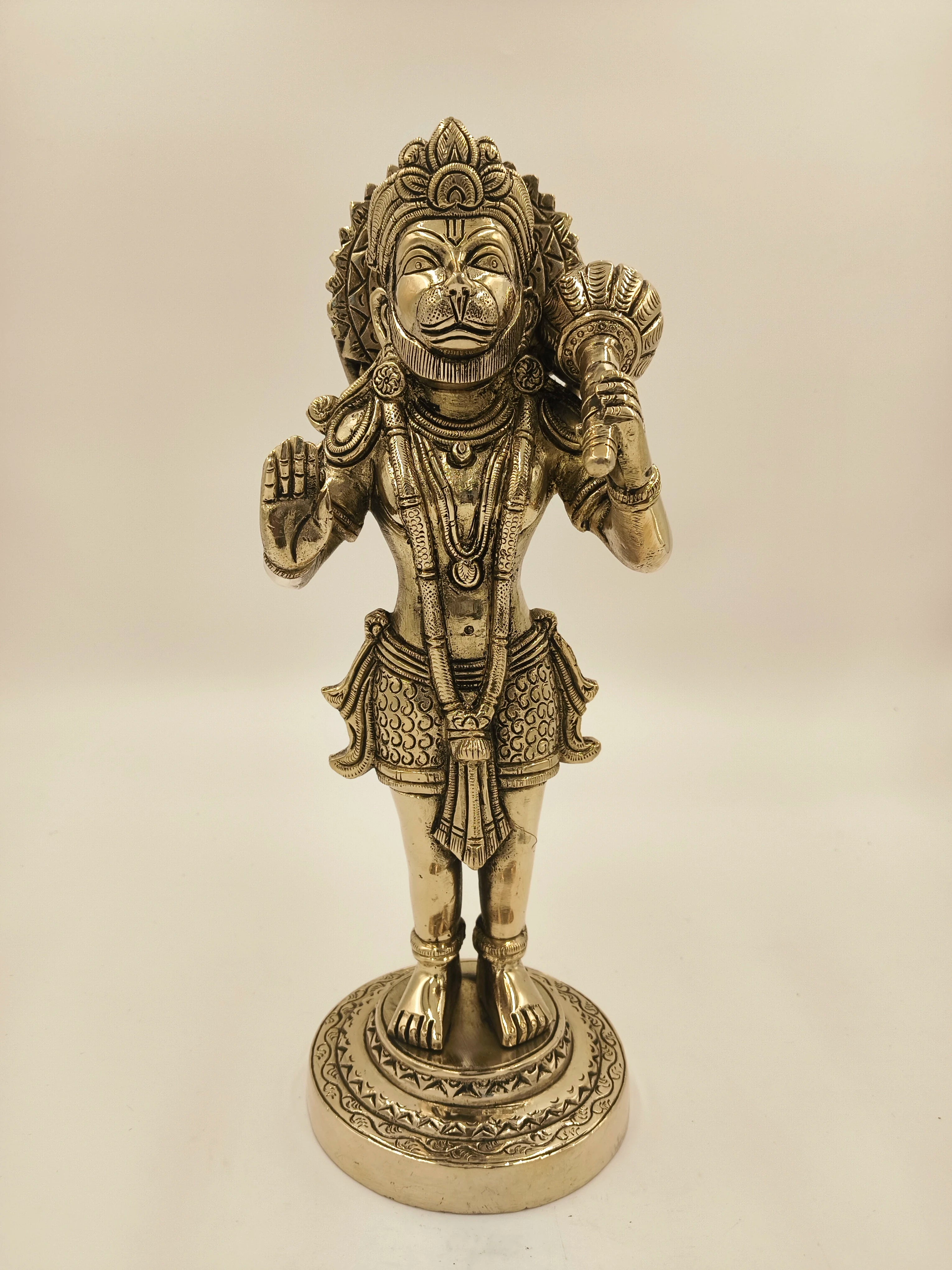 Large brass figurine of Hanuman holding a mace, standing on a decorative base