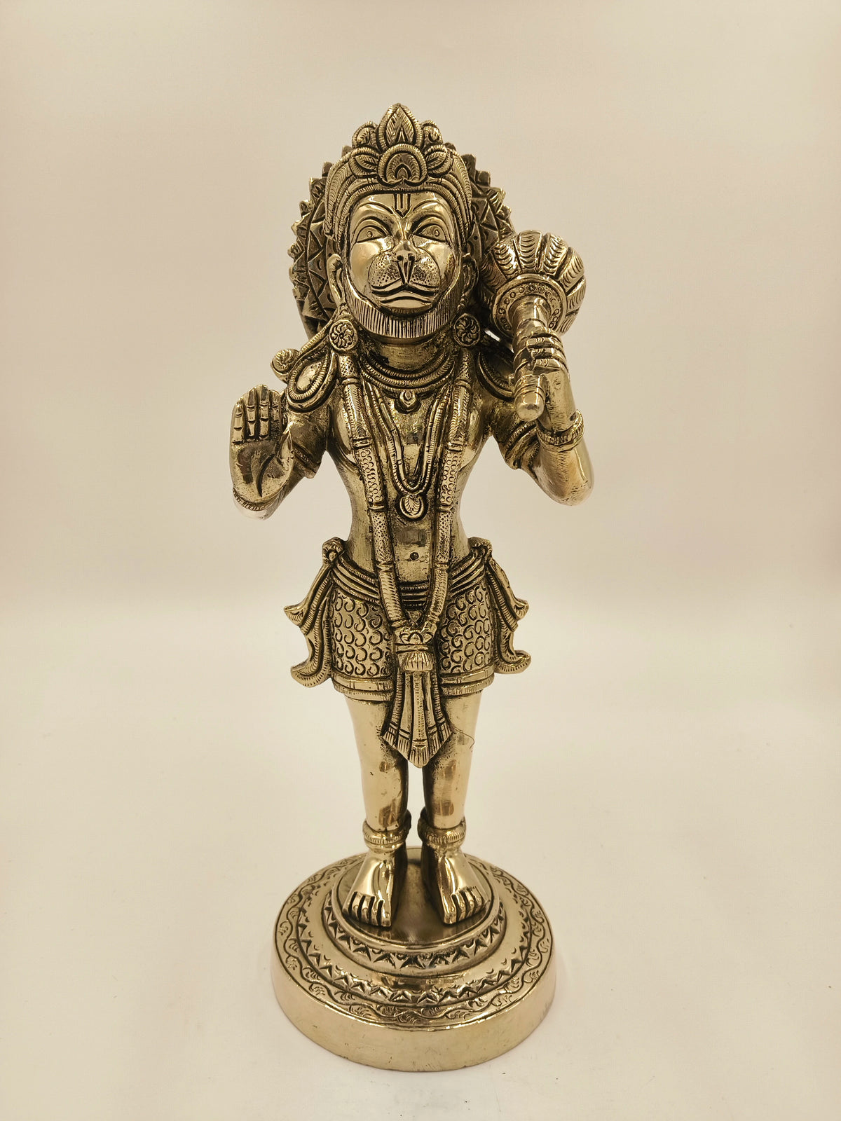Large brass figurine of Hanuman holding a mace, standing on a decorative base