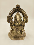 Large brass statue of Ganesh seated with ornate arch and detailed carvings