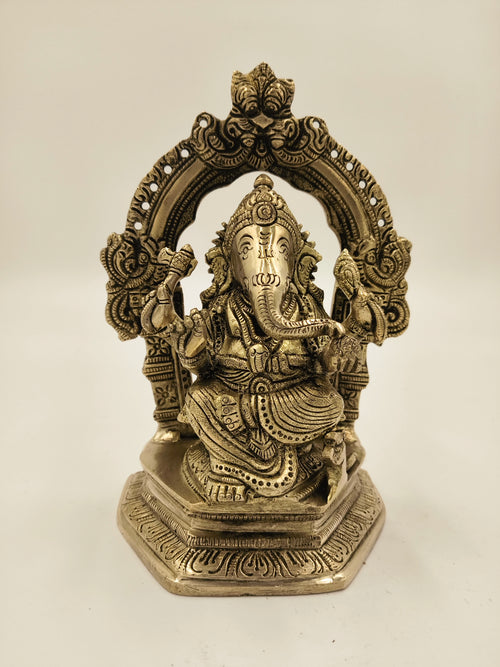 Large brass statue of Ganesh seated with ornate arch and detailed carvings