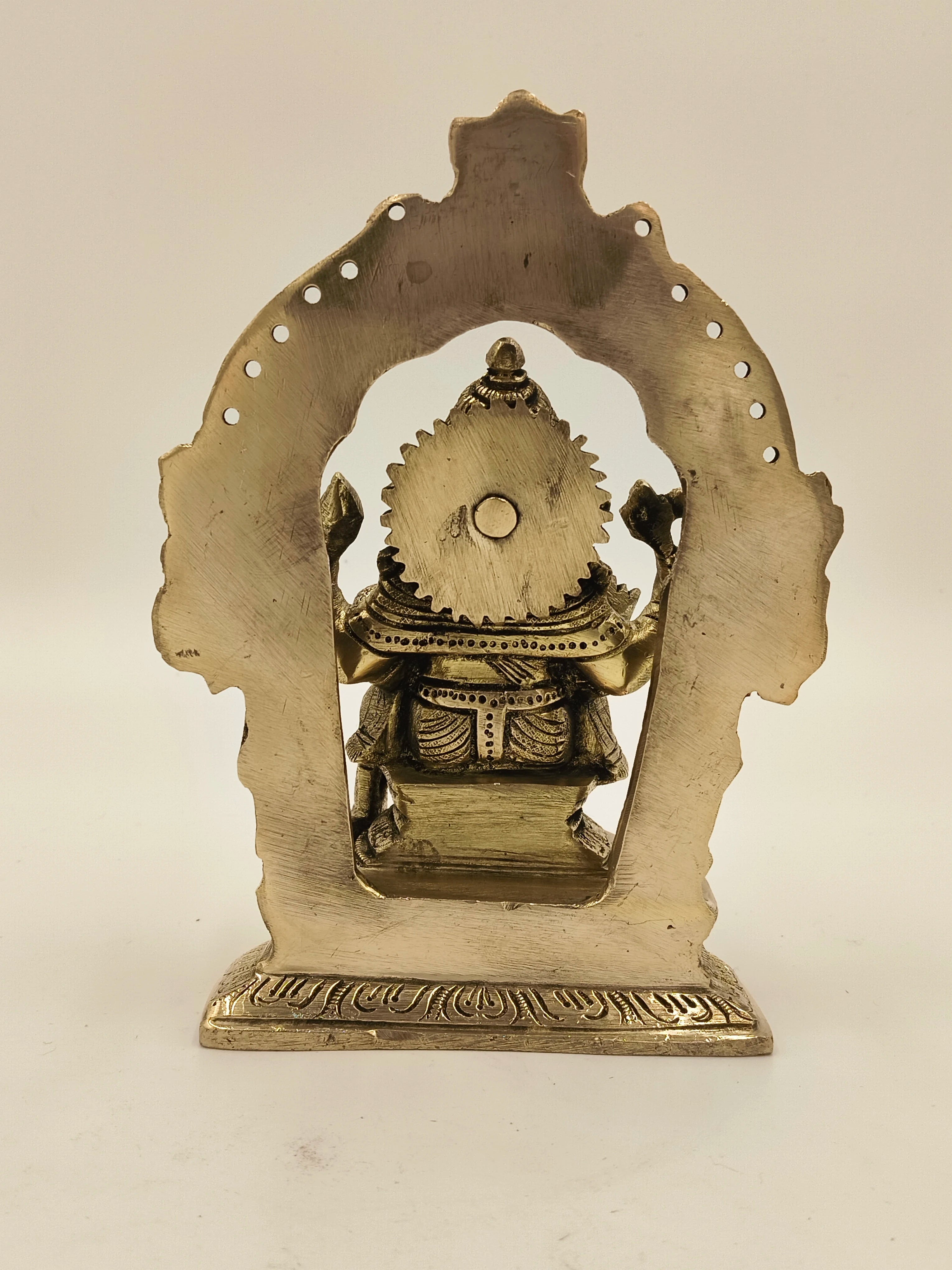 Back view of large brass Ganesh idol with decorative arch frame
