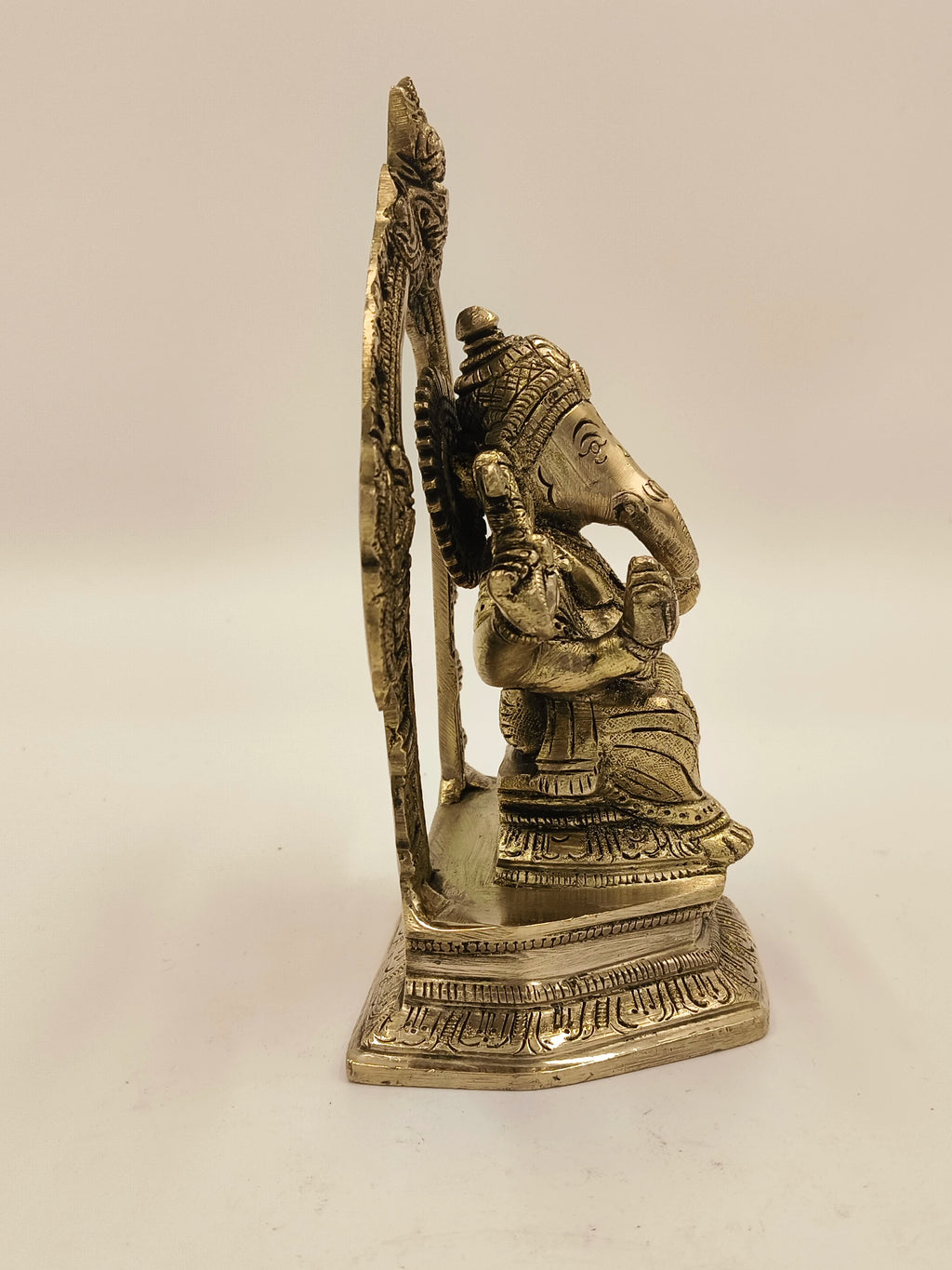 Side view of brass Karya Siddi Ganapathi statue with detailed carvings