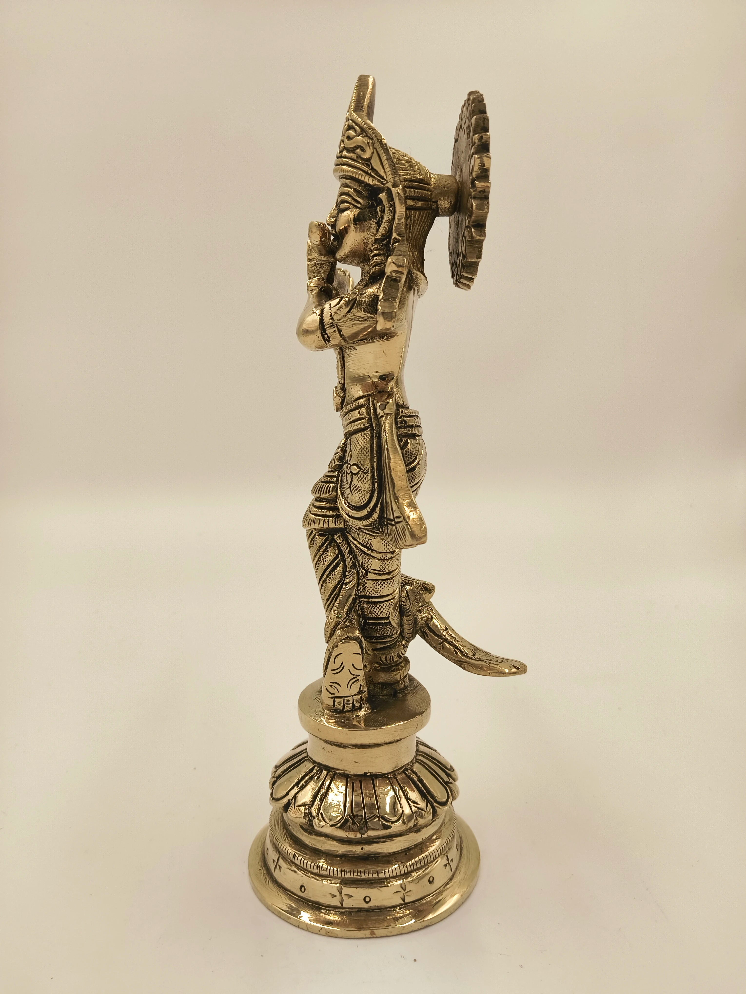 Side view of large brass sculpture of Krishna as Gokula Nandana standing on ornate pedestal
