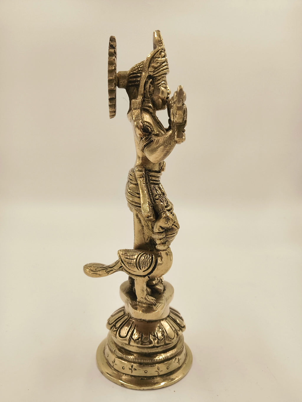 Side view of large brass Krishna Gokula Nandana sculpture with detailed base