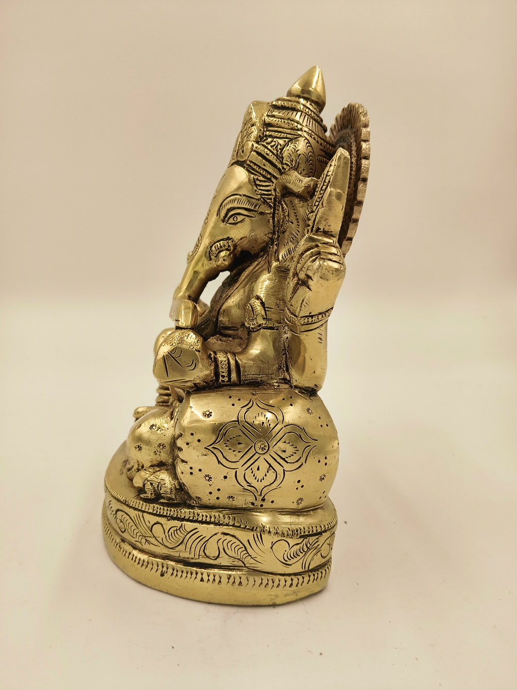 Side view of brass Swarna Ganesh statue with intricate engravings