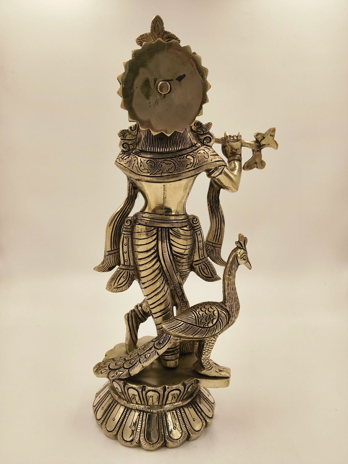 Back view of large brass Govardhan Giridhari Krishna statue with peacock