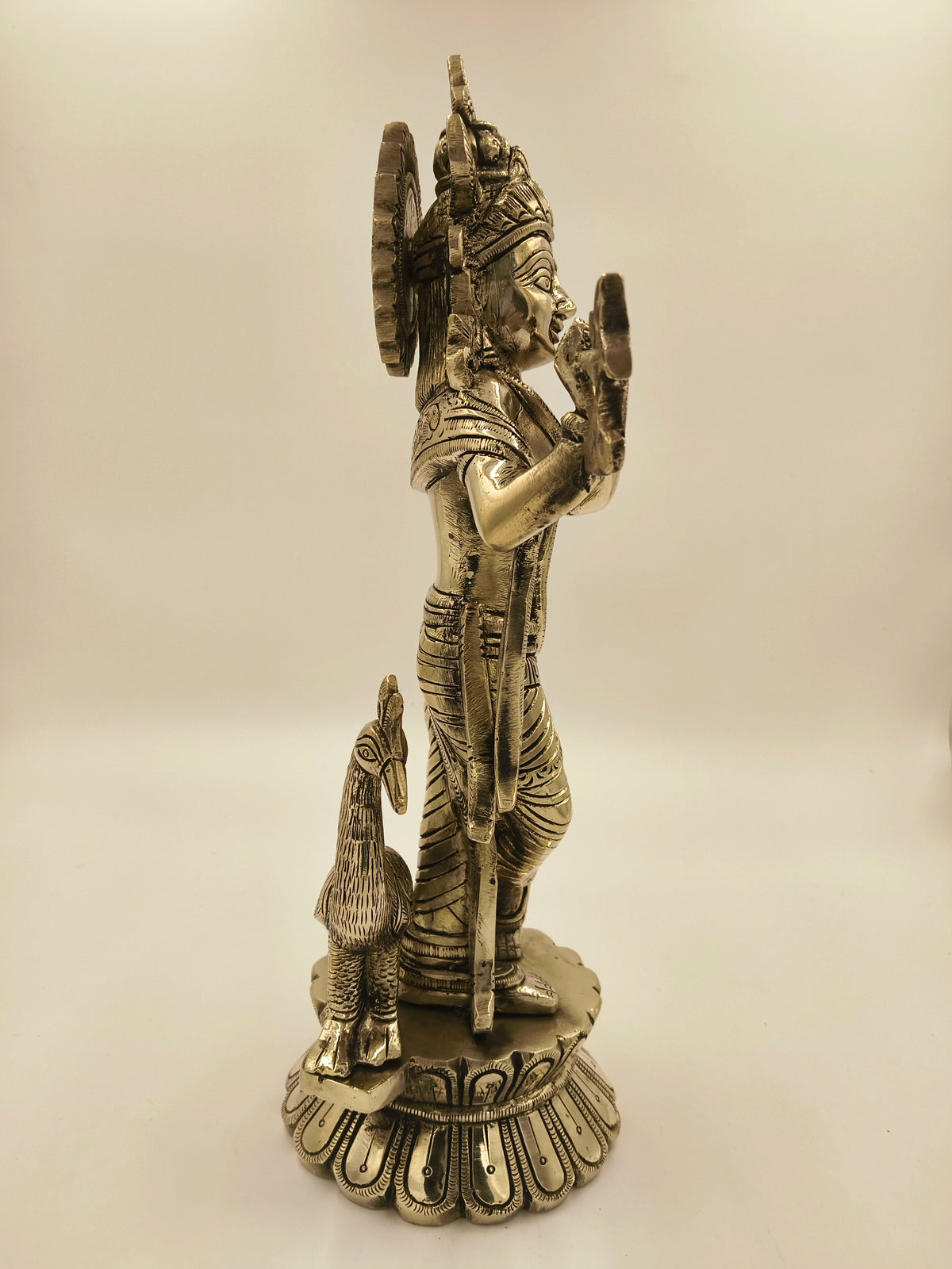 Side view of large brass Govardhan Giridhari Krishna sculpture with peacock