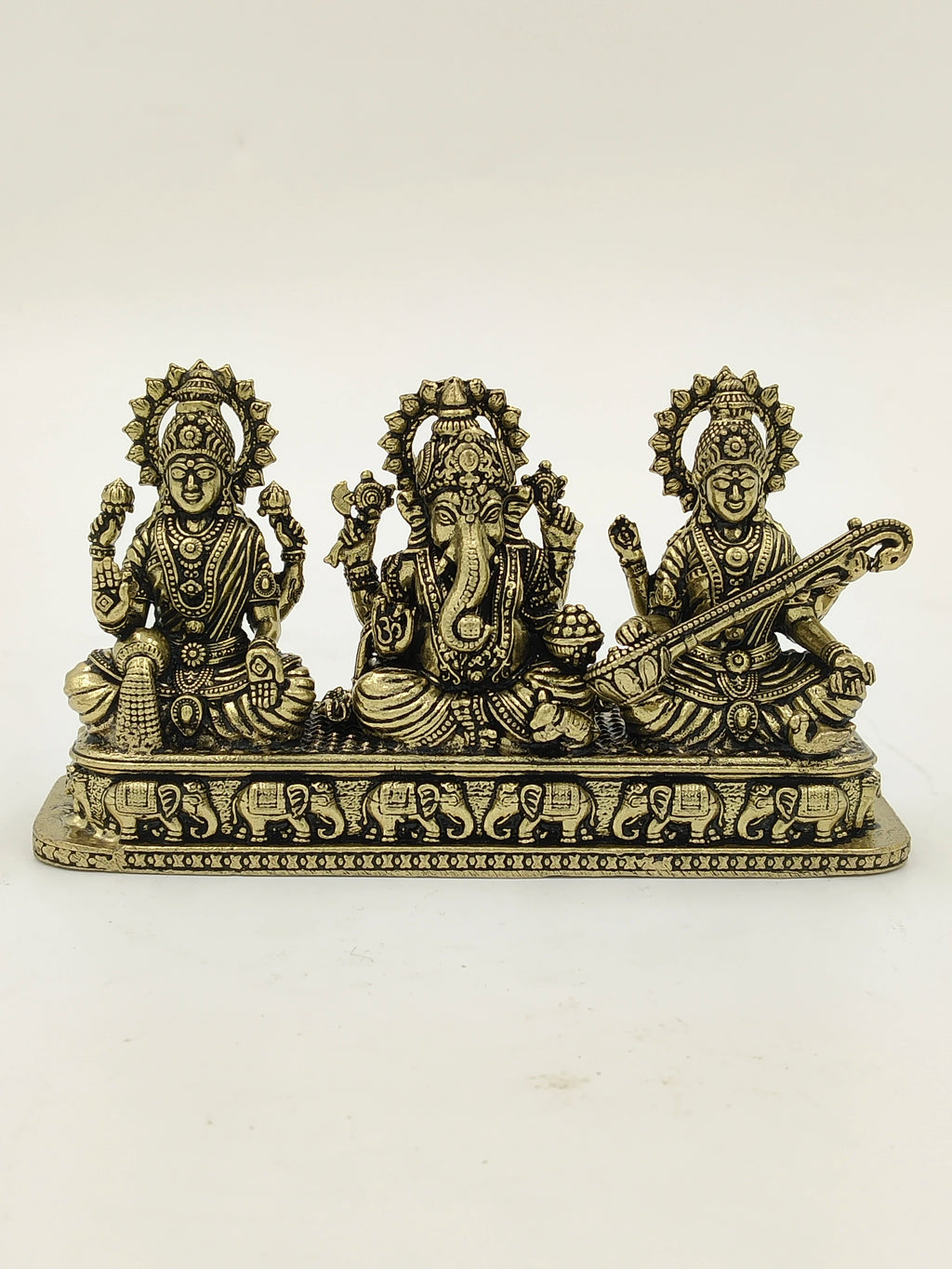 Mini brass sculpture of Lakshmi, Ganesh, and Saraswathi gods on engraved base