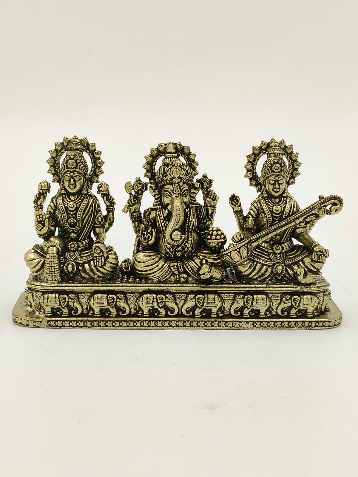 Mini brass sculpture of Lakshmi, Ganesh, and Saraswathi gods on engraved base