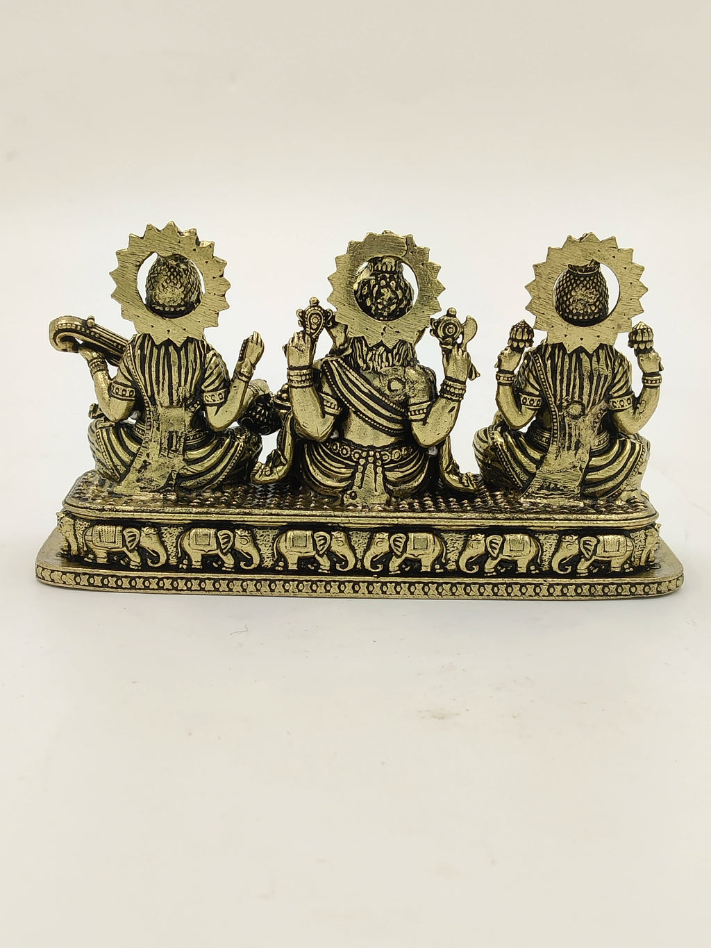 Back view of brass sculpture featuring Lakshmi, Ganesh, and Saraswathi idols