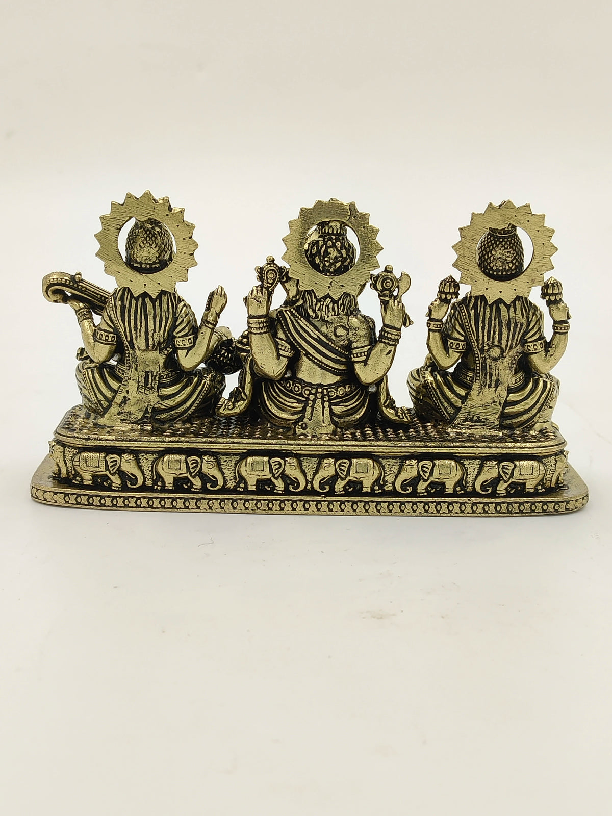 Back view of brass sculpture featuring Lakshmi, Ganesh, and Saraswathi idols