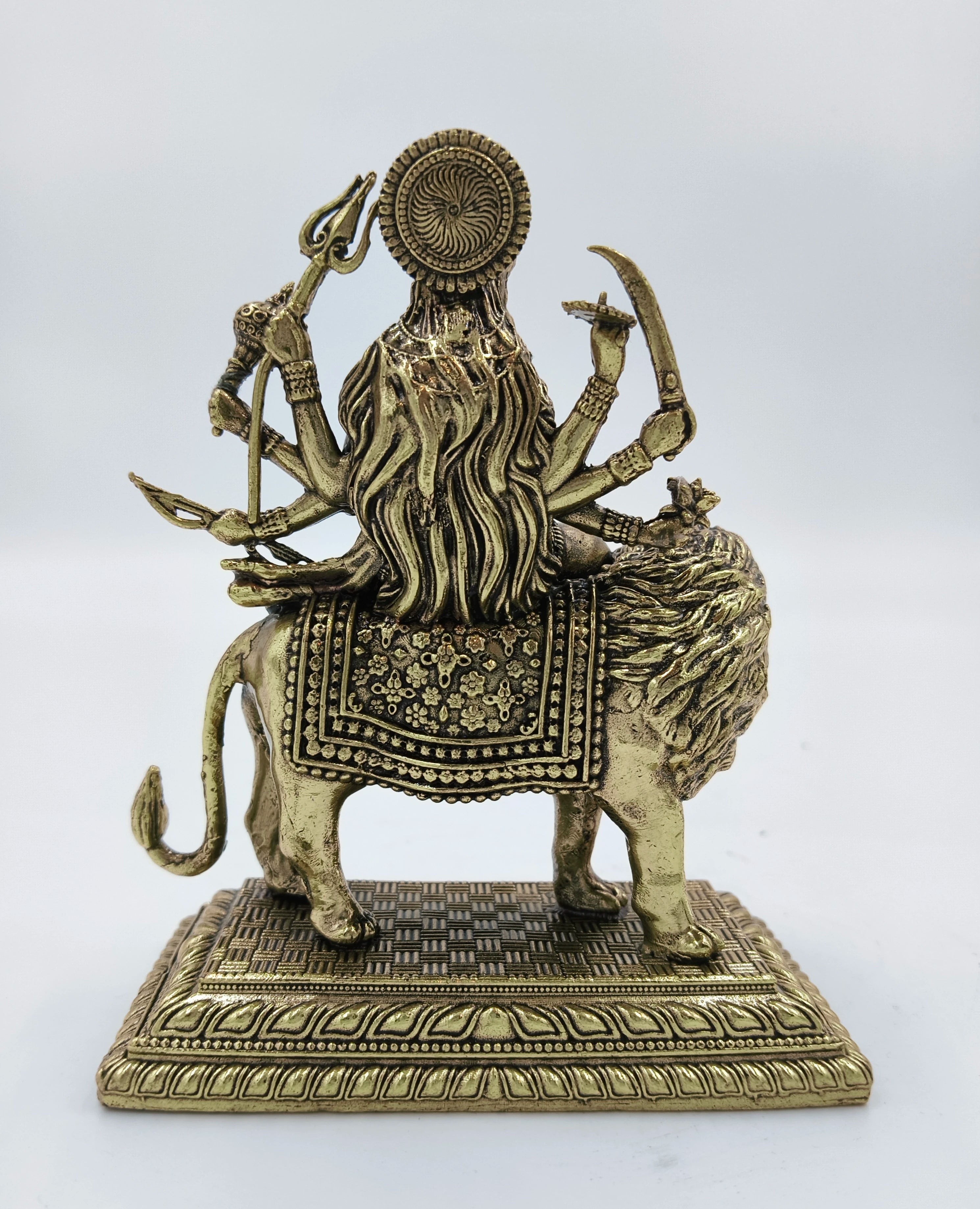 Back view of medium brass Durga statue seated on lion with detailed base