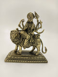 Small brass sculpture of Hindu goddess Durga riding a lion on a detailed base