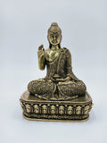 Small brass Buddha statue seated on an ornate pedestal, front view