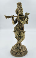 Large brass statue of Krishna playing flute with detailed ornamentation
