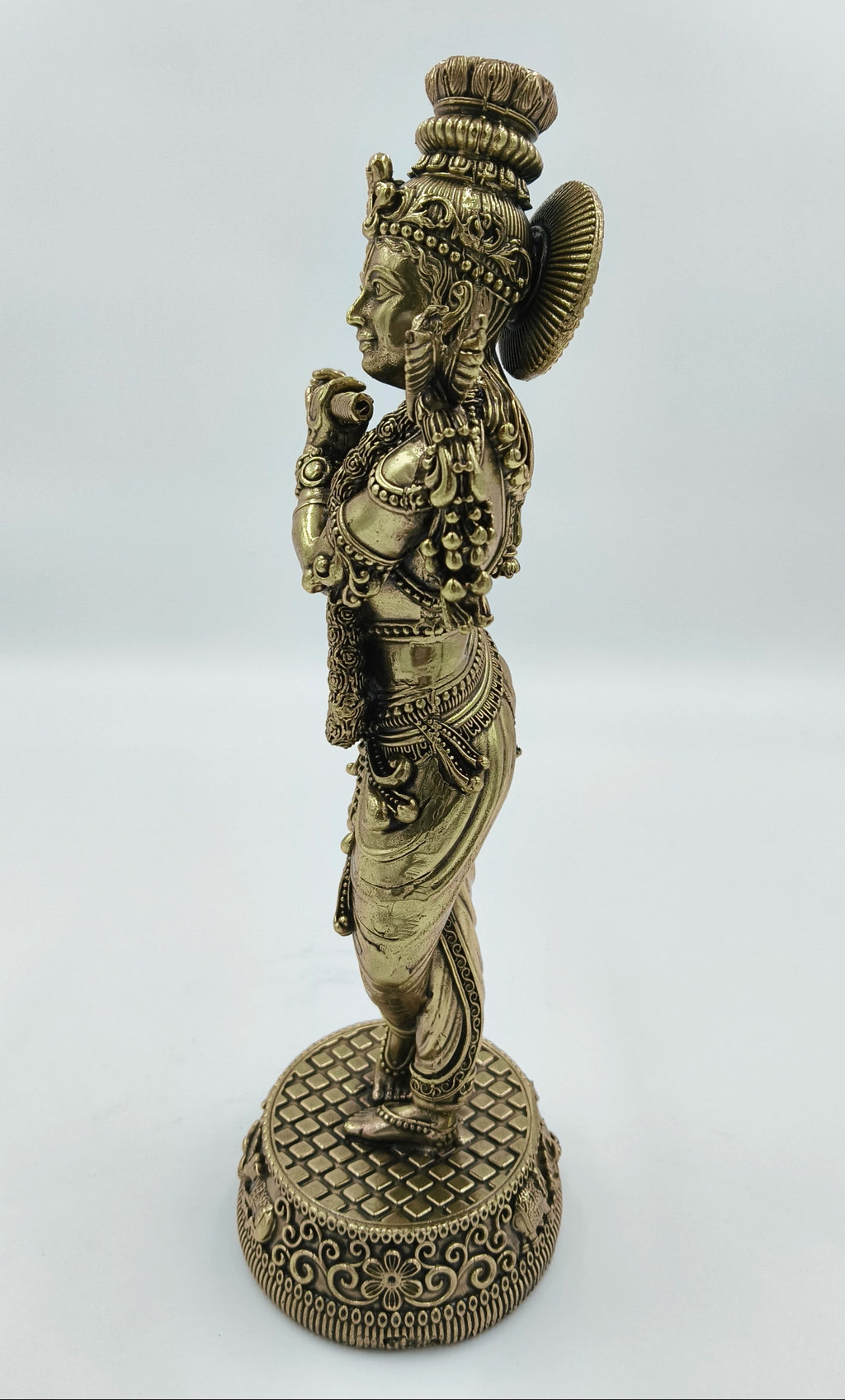 Side view of large brass Krishna Venumadhava sculpture on decorative base