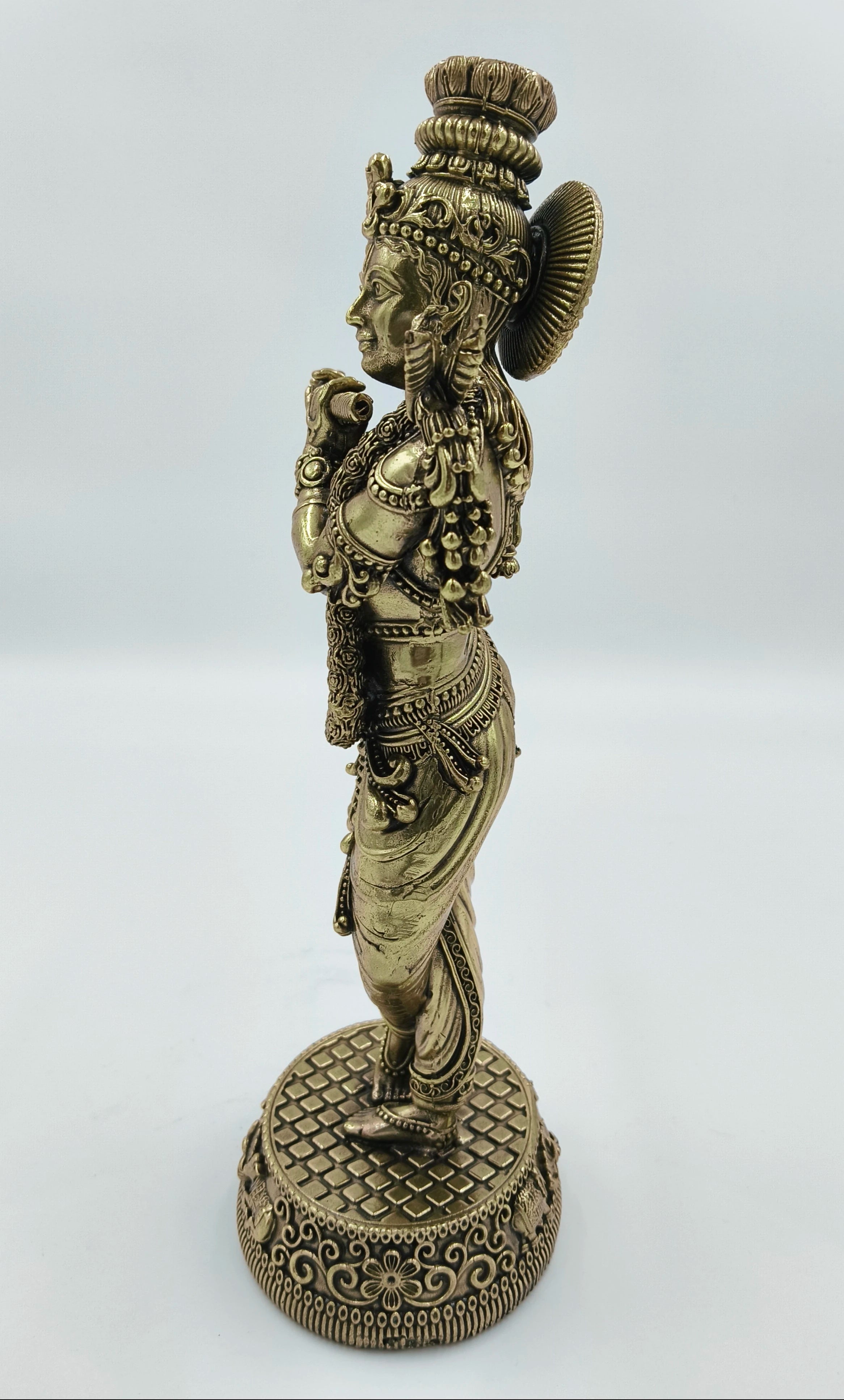 Side view of large brass Krishna Venumadhava sculpture on decorative base