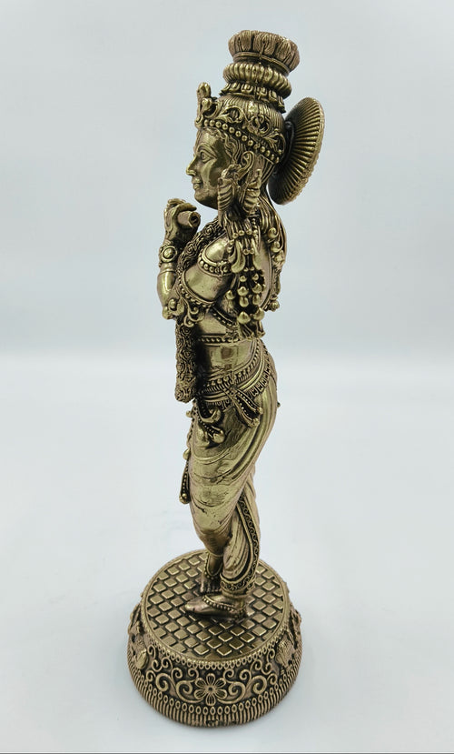 Side view of large brass Krishna Venumadhava sculpture on decorative base