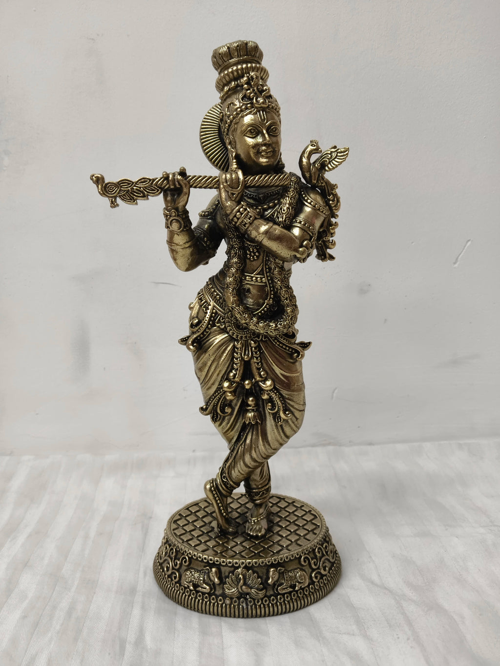 Large brass statue of Lord Krishna playing flute in traditional attire
