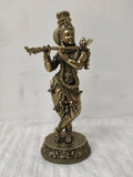 Large brass statue of Lord Krishna playing flute in traditional attire