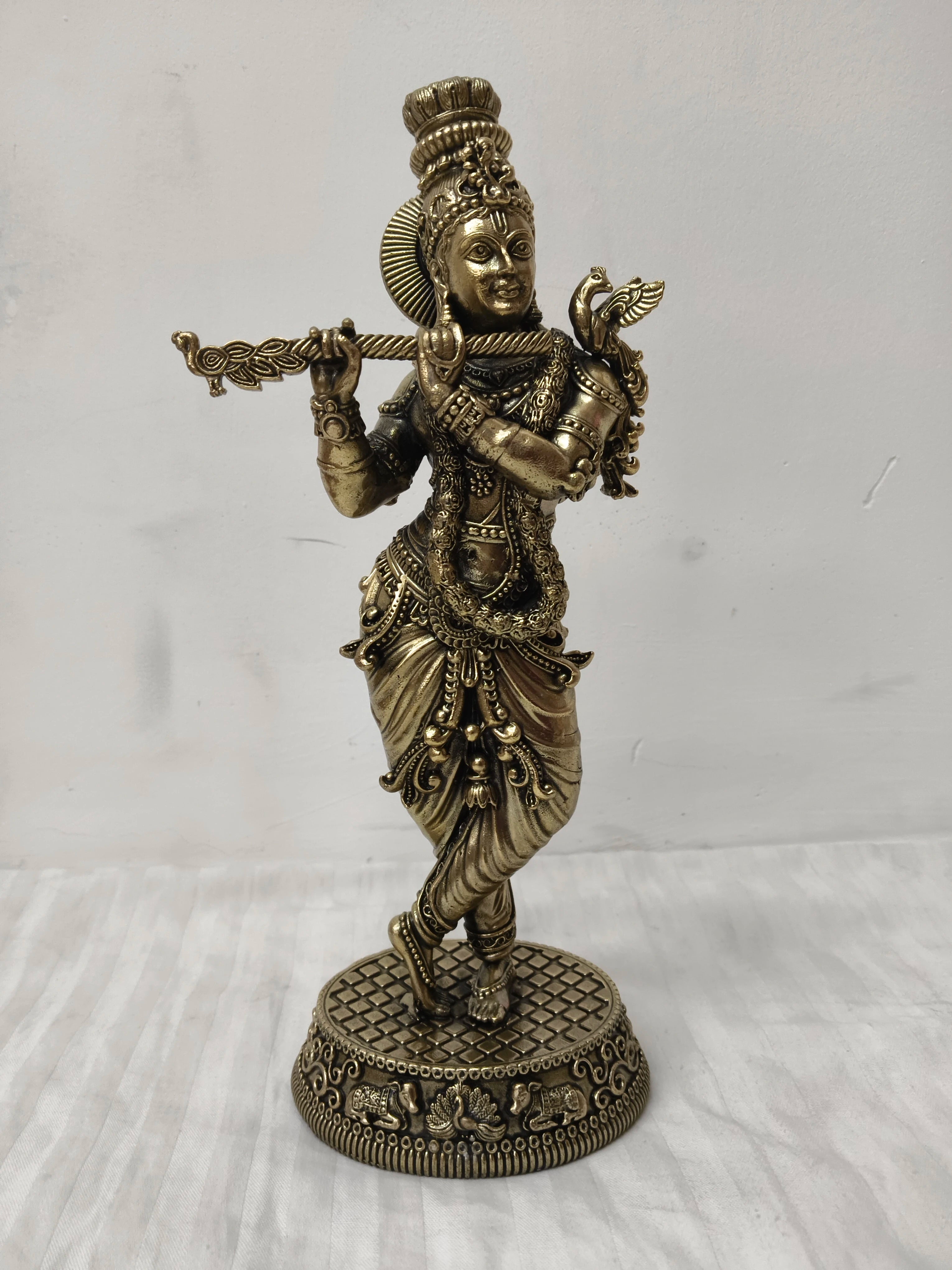 Large brass statue of Lord Krishna playing flute in traditional attire