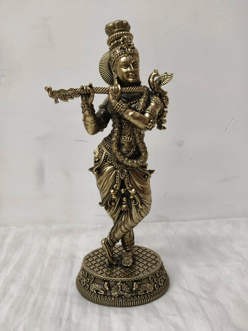 Large brass statue of Lord Krishna playing flute in traditional attire