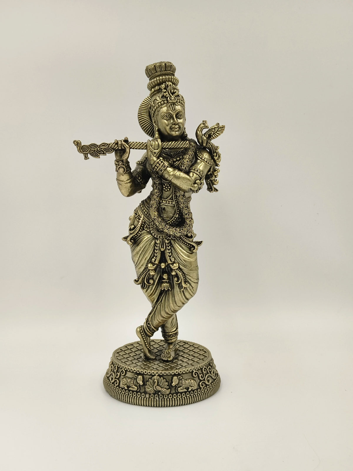Large brass statue of Lord Krishna playing flute in traditional attire