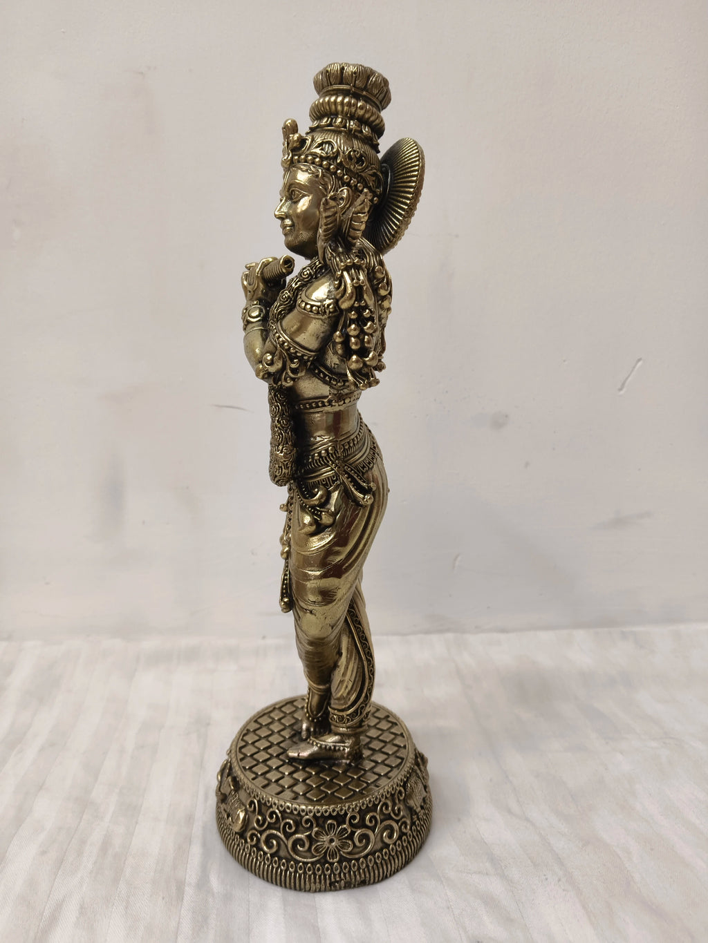 Side view of a large brass Venumadhava Krishna statue on decorative base