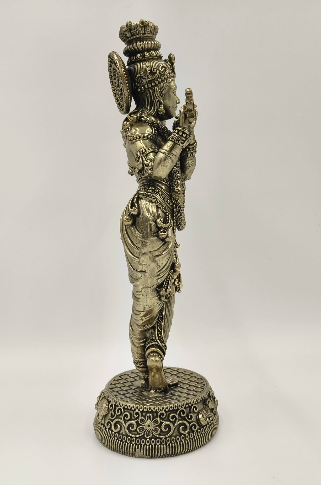 Side view of a large brass Venumadhava Krishna statue on decorative base