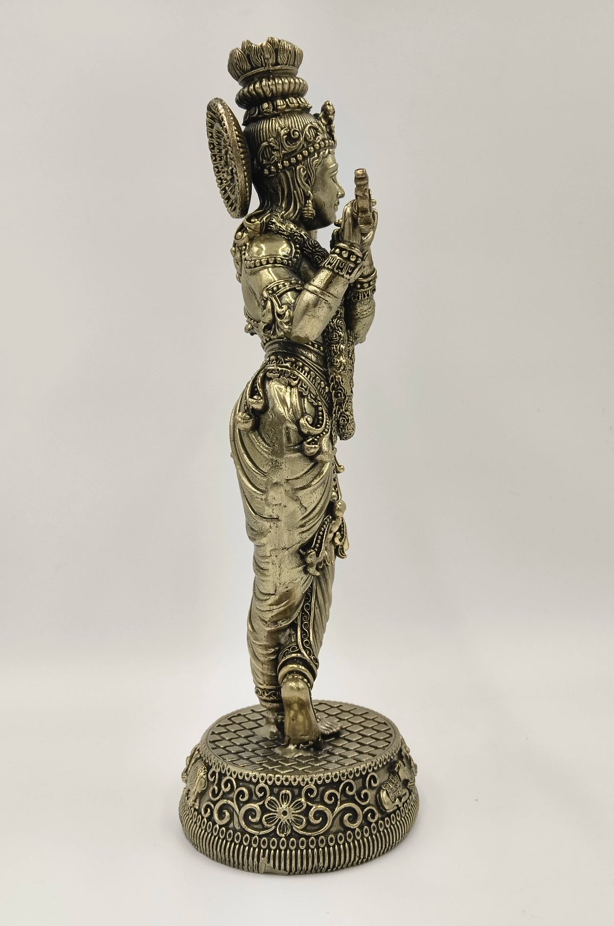Side view of a large brass Venumadhava Krishna statue on decorative base