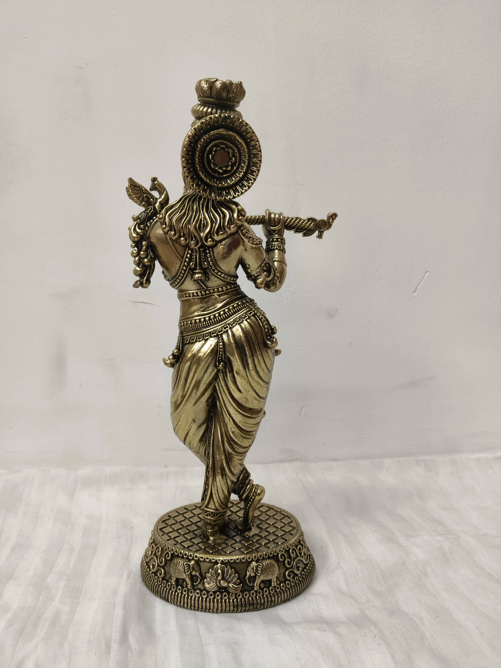 Back view of large brass Venumadhava Krishna statue playing flute