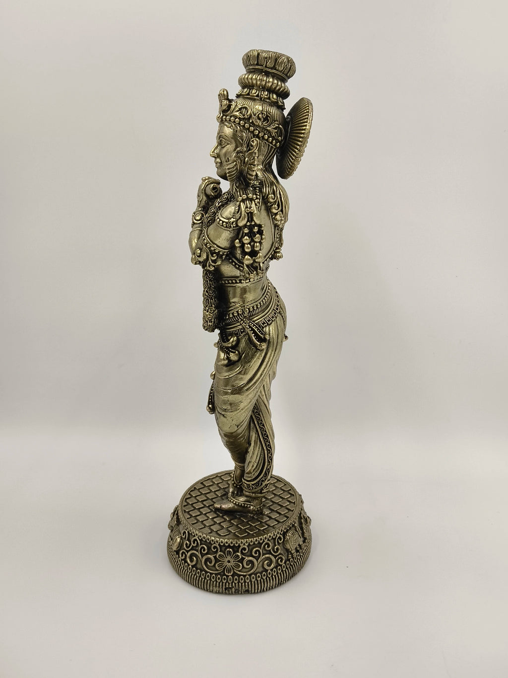 Side view of large brass Venumadhava Krishna statue standing on decorative base