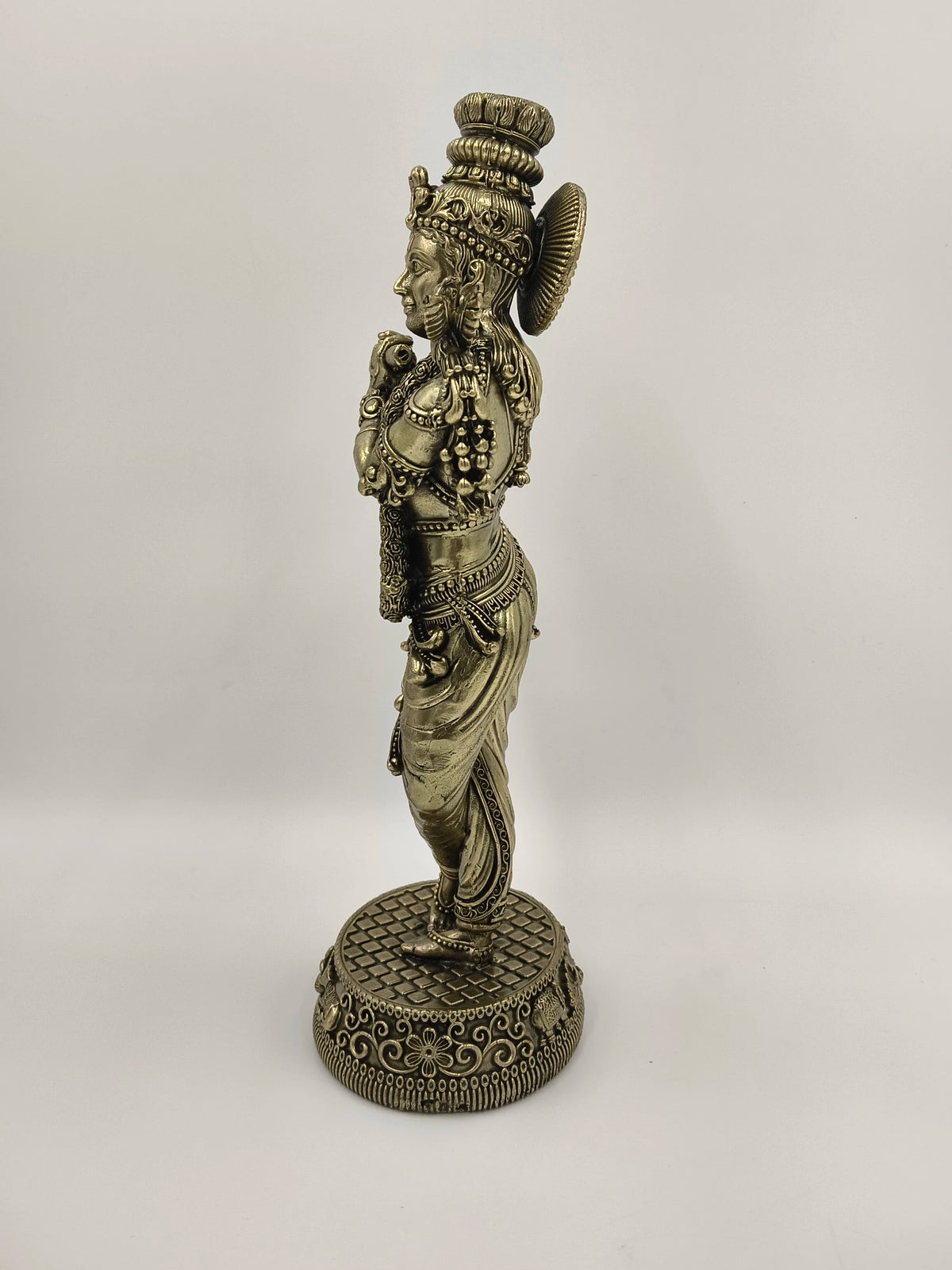 Side view of large brass Venumadhava Krishna statue standing on decorative base