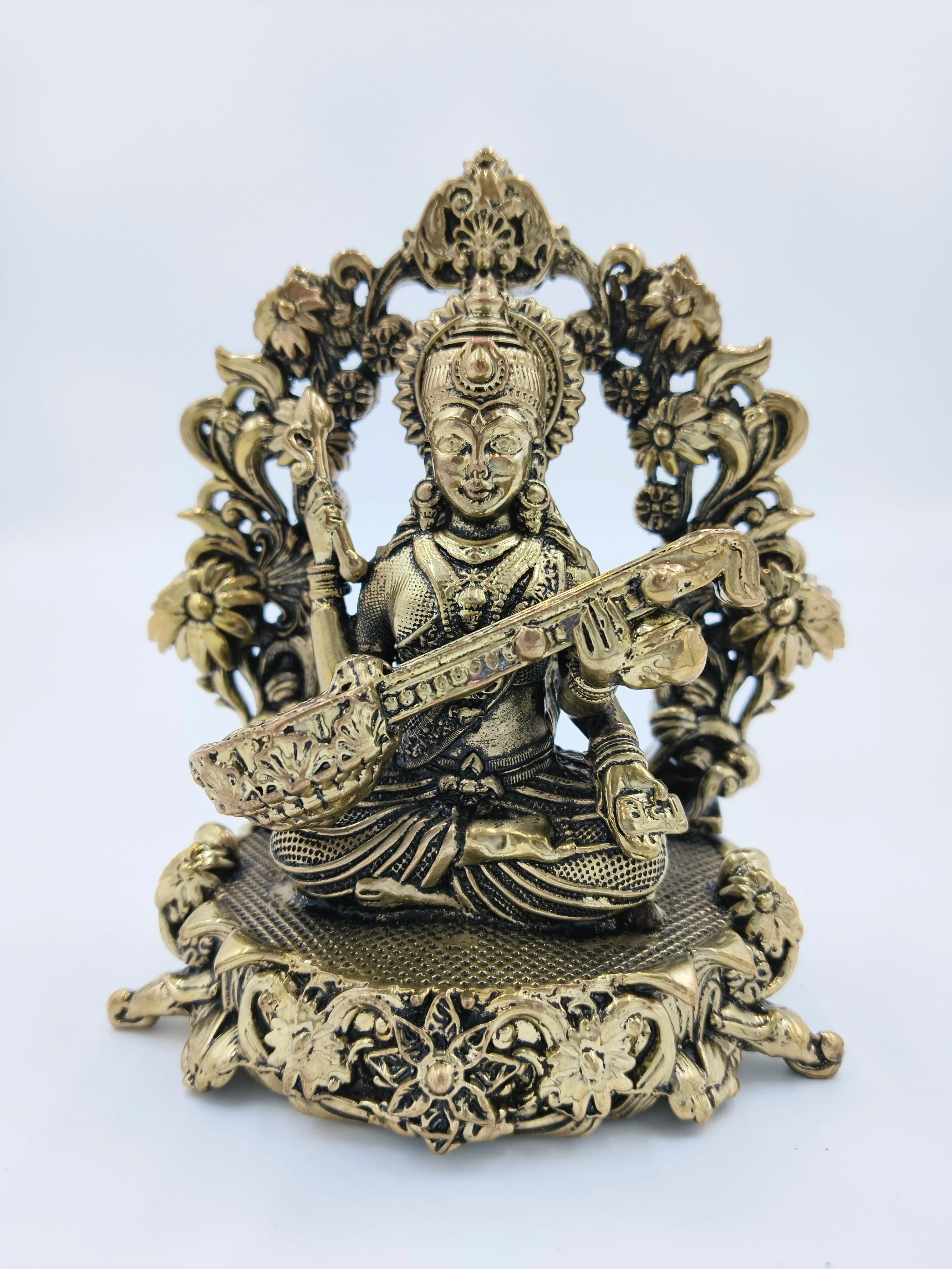 Medium brass sculpture of Goddess Saraswathi playing veena with floral ornate base
