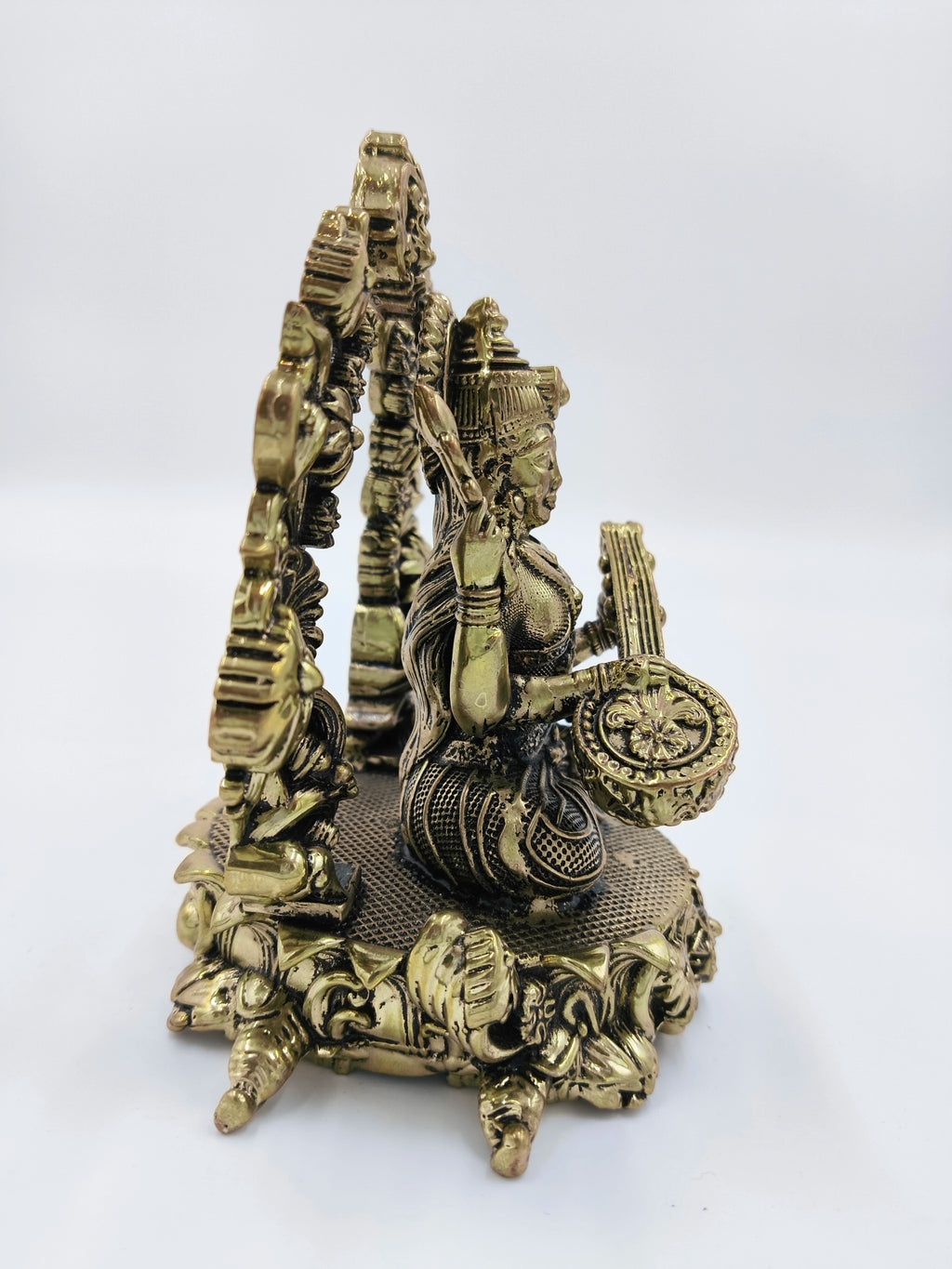 Brass statue of Vagdevi KalaMurti deity playing musical instrument, side view