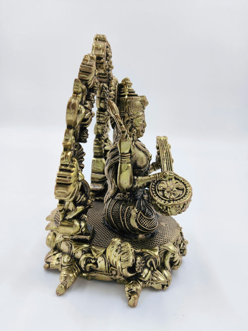 Brass statue of Vagdevi KalaMurti deity playing musical instrument, side view